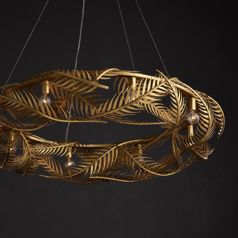 An image of the Queenbee palm Ring Chandelier in gold made of wrought iron with a black background.